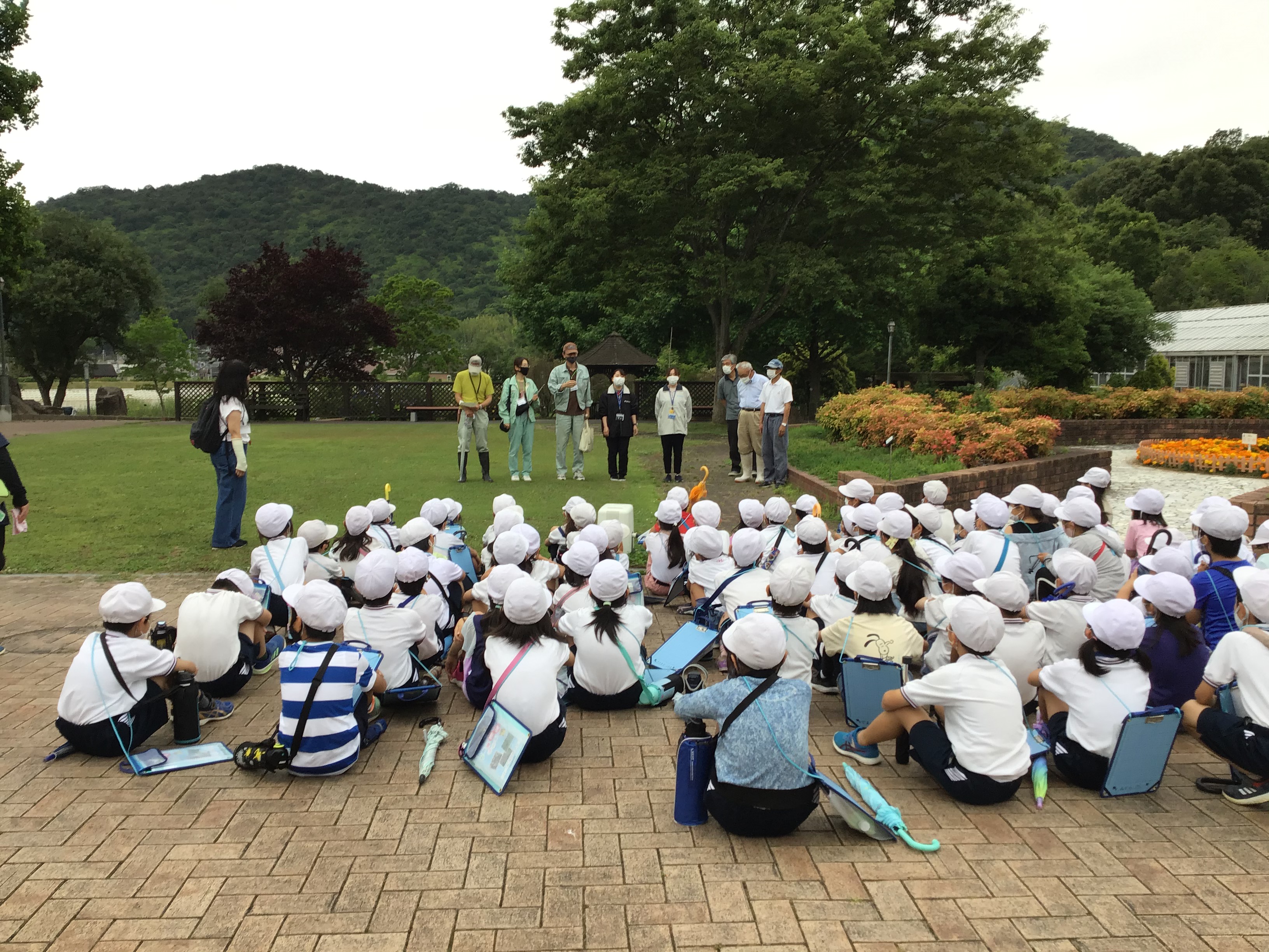 阿弥陀小学校5年生83人に挨拶する講師陣。手柄山温室植物園の松本修二さん(黄色の服)が先陣を切って挨拶。